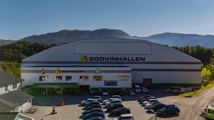 Dronefoto av Sodvinhallen med parkeringsplass. Flere bilder parkert.